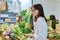 Adult woman choosing buying vegetables fruits berries greens at farmers market