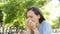 Adult woman coughing in a park