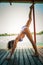Adult woman doing yoga in bikini on wooden river raft