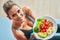 Adult woman eating healthy lunch and sitting on yoga mat