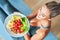 Adult woman eating healthy lunch and sitting on yoga mat