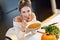 Adult woman eating pumpkin soup in the kitchen