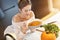 Adult woman eating pumpkin soup in the kitchen