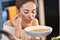 Adult woman eating pumpkin soup in the kitchen