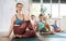 Adult woman with family practicing yoga in studio