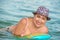 ADULT WOMAN IN A HAT SWIMS IN  SEA