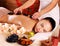 Adult woman having hot stone massage in spa salon