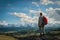 Adult woman hiker stands on the top enjoys mountain views