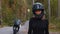 Adult woman motorbike rider fixes her helmet and looking in the camera