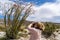 Adult woman photographer takes pictures of a flowering Ocotillo plant in bloom in Anza Borrego State Park during the California