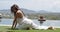 Adult woman in pigeon pose near swimming pool against beautiful scenery of coast in sunny day