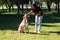 Adult woman playing with her dog in the park and having fun. One more in the family. Pets concept. 4 October World Pet Day