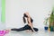 Adult woman practice yoga pigeon pose indoor full body shot