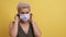 Adult woman puts on a medical mask and makes a sad face. Woman in a white medical mask frowns her eyebrows. High quality