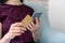 Adult woman sitting in cafe and using modern smartphone and bank card