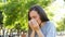 Adult woman sneezing in a park