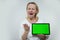 adult woman with a tablet in her hands is very surprised she does not like what she sees on it shows a green chromakey