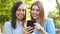 Adult woman and teen checking smart phone