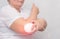 An adult woman treats the elbow joint with a magnetic field, relieves pain and inflammation with a medical magnet, physiotherapy