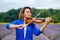 Adult woman violinist playing violin on summer lavender field closeup