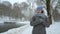 Adult woman walking alone in winter park on snowy day