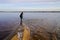 Adult woman walks alone in winter along sand lake beach