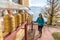 Adult woman wearing sunglasses looking at the prayer wheels of a Tibetan Buddhist temple at Mont Pelerin, Switzerland.