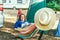 Adult woman working on laptop pc while lying in hammock near motorhome on camping trip. Female living on camper car and travel the