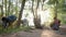 Adult women are cleaning territory of countryside forest in summer day, putting waste in big black bags