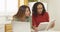 Adult women college students reading book and using laptop computer to study