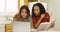 Adult women college students reading book and using laptop computer to study