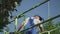 Adult worker cuts leaves at the tree