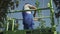 Adult worker cuts leaves at the tree