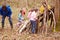 Adults And Children Building Camp At Outdoor Activity Centre