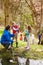 Adults And Children Exploring Pond At Activity Centre