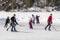 Adults and children play hockey on a frozen lake