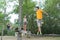 Adults crossing rope bridge