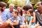 Adults and kids sitting on the grass in a garden