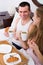 Adults posing with coffee and pastry for breakfast