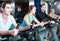Adults riding stationary bicycles in fitness club