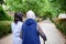 Advanced geriatric psychotherapist strolling with elderly female patient in a green alley