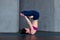 Advanced young yogini practicing Hatha yoga standing in inverted lotus pose, padmasana, on mat