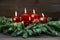 Advent decoration wreath with four red burning candles and light
