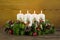 Advent wreath or crown with four burning white candles.