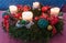 Advent wreath with four lighted white candles and red ribbons