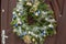 Advent wreath handmade from evergreen spruce branches, decorated with gold, silver and blue Christmas toys, beads and artificial