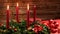Advent wreath with three burning candles and festive decoration in front of a vintage wooden wall