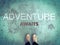 Adventure awaits word and feet wear white sneakers shoe on blue road