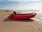 Adventure is calling...A red dingy on the beach on a summers day.