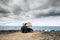 Adventure concept for caucasian man sit down and rest on the roof of his car with tent - traveler wanderlust lifestyle and